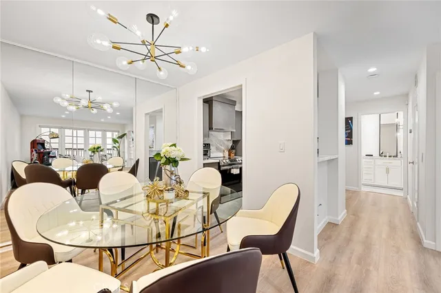 a dining room with furniture a chandelier and wooden floor