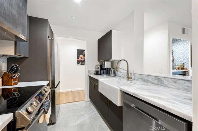 a dining hall with stainless steel appliances kitchen island granite countertop a table chairs in it and a window