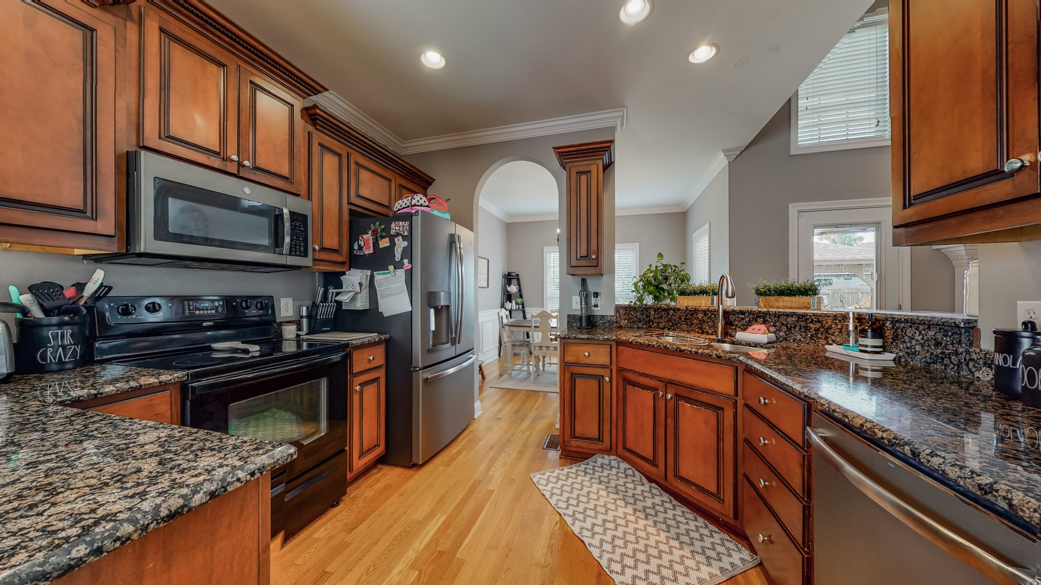 727 Heritage Road Lebanon, TN 37087 - Photo 35 of 58 a kitchen with stainless steel appliances granite countertop a stove top oven a sink dishwasher a dining table and chairs with wooden floor