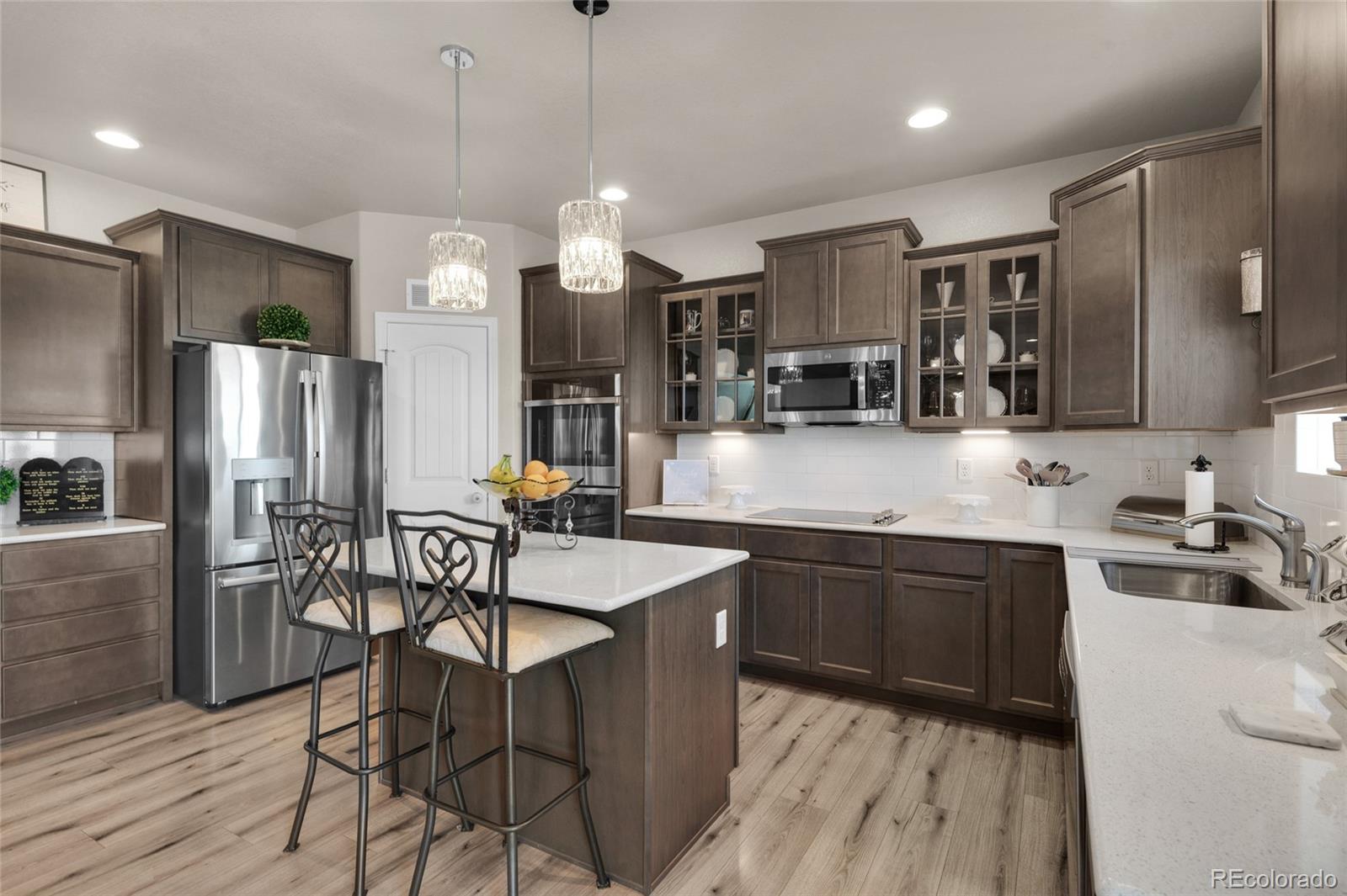 9033 Yellowtail Way Colorado Springs, CO 80908 - Photo 11 of 39 a kitchen with granite countertop a table chairs microwave and refrigerator