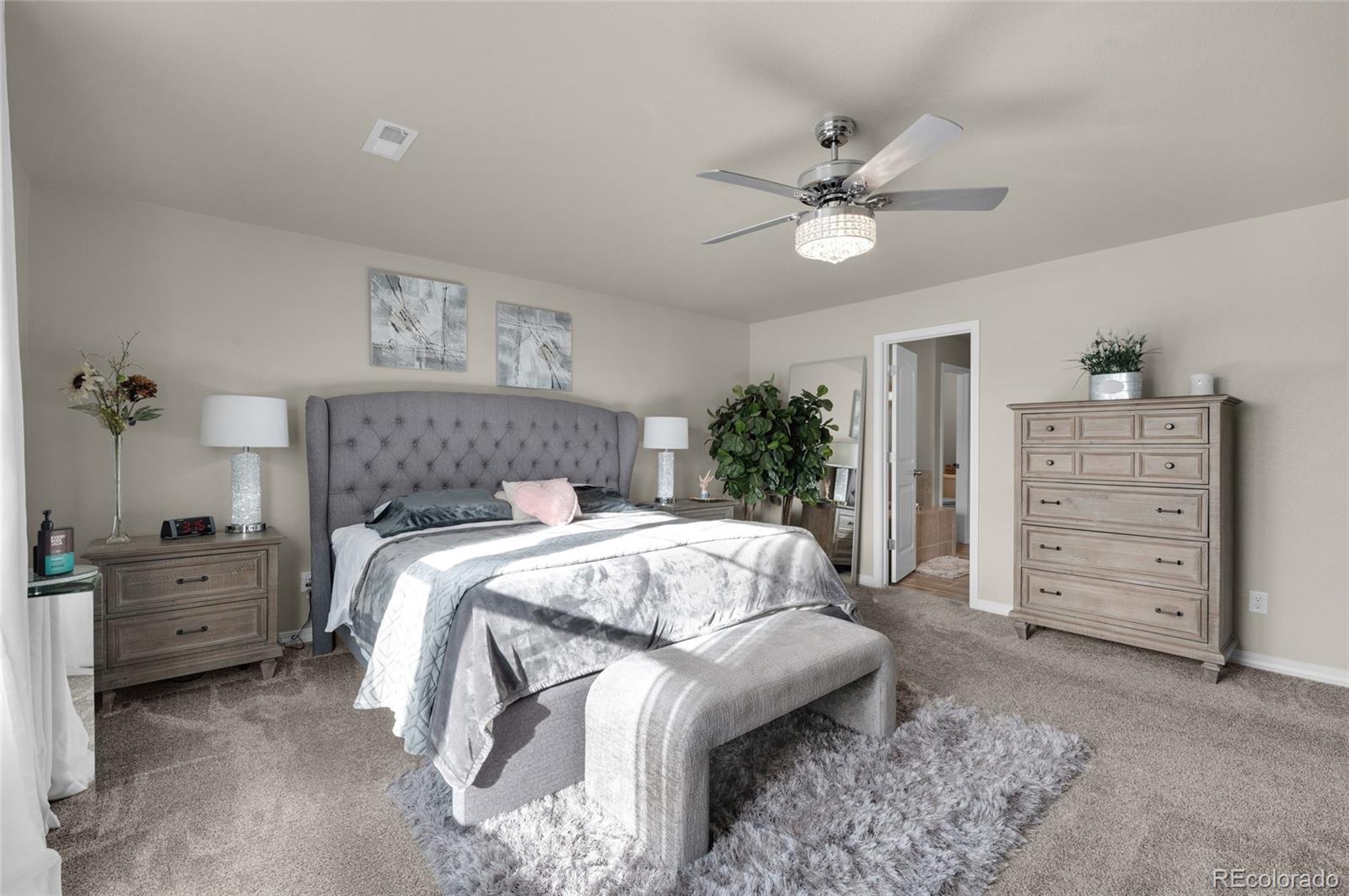 9033 Yellowtail Way Colorado Springs, CO 80908 - Photo 22 of 39 a bedroom with a bed and a chandelier