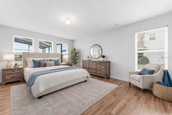 a spacious bedroom with a bed windows and couch