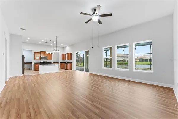 a view of an empty room with a kitchen stove and wooden floor