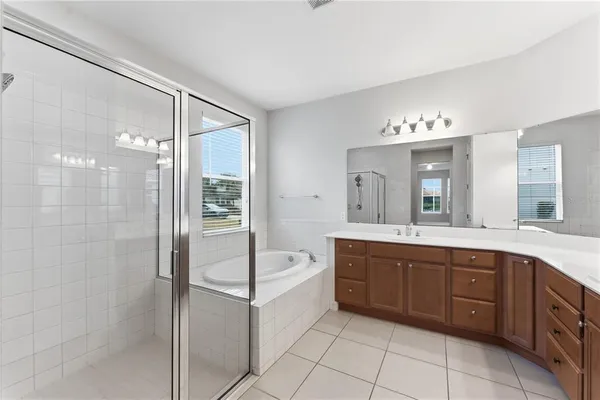 a spacious bathroom with a double vanity sink mirror and bathtub
