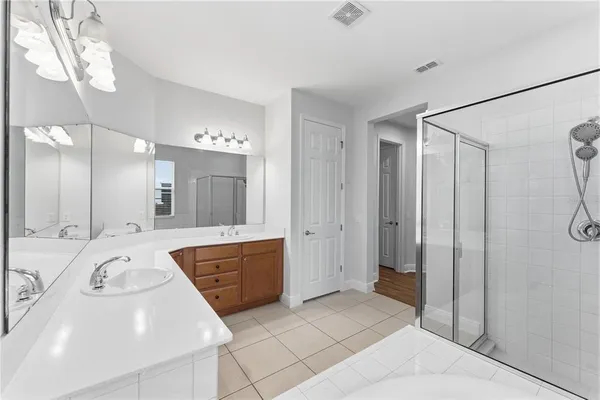 a large bathroom with a tub a sink shower and mirror