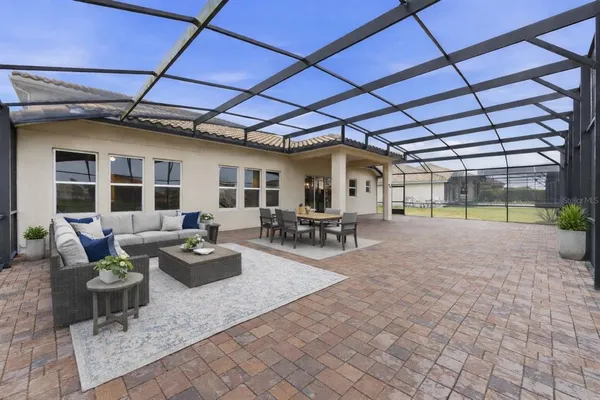 a view of a patio with couches and chairs under an umbrella