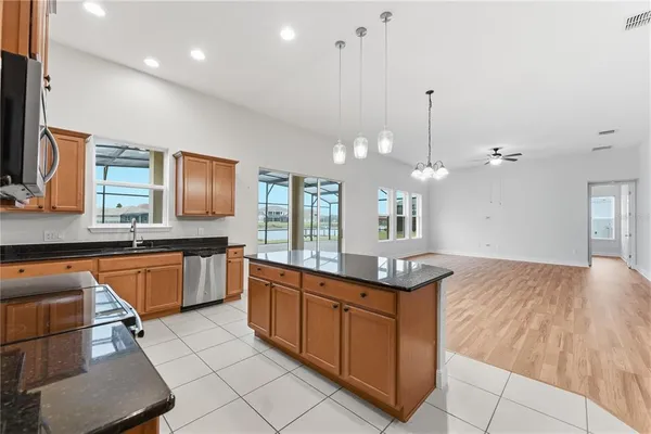 a kitchen with stainless steel appliances granite countertop a sink a stove counter space and cabinets