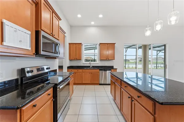 a kitchen with stainless steel appliances granite countertop a stove a sink and a microwave