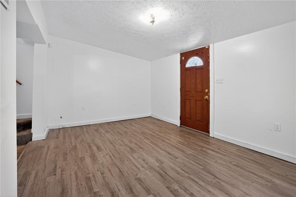 417 Alexander Street McKees Rocks, PA 15136 - Photo 3 of 21 a view of an empty room with wooden floor and a window