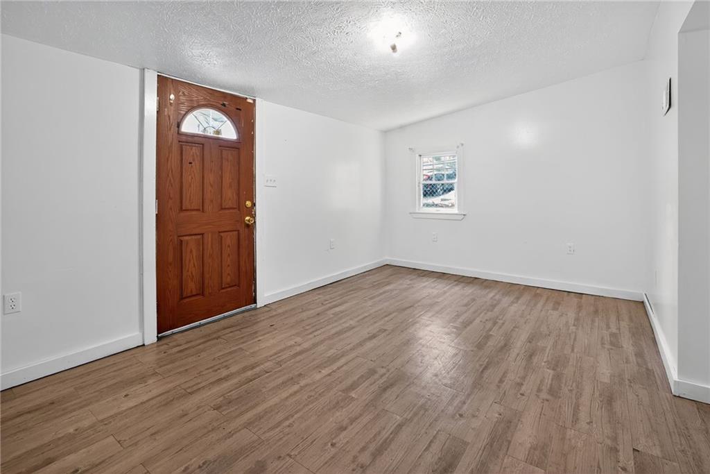 417 Alexander Street McKees Rocks, PA 15136 - Photo 4 of 21 an empty room with wooden floor and windows