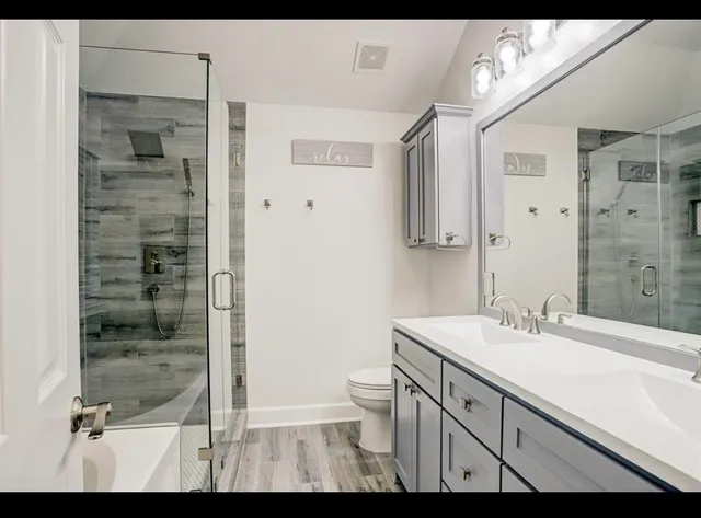 a bathroom with a sink a toilet and shower