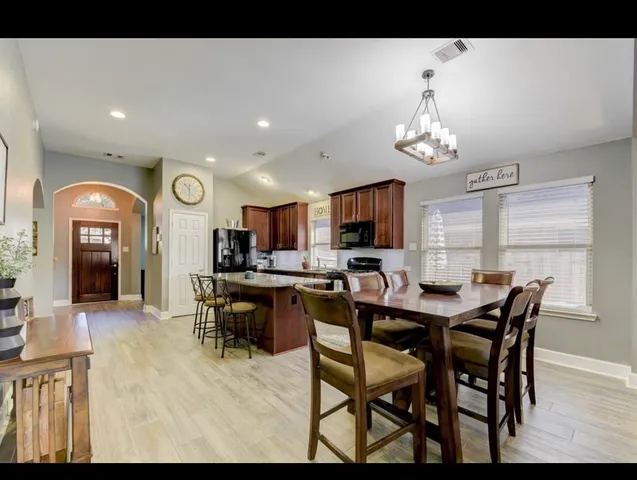 a view of a dining room with furniture and a chandelier