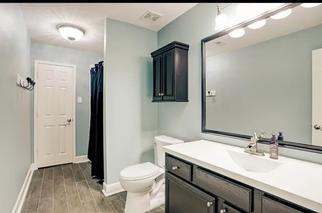 a bathroom with a sink a toilet and shower