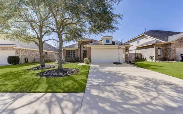 a front view of a house with a garden and tree