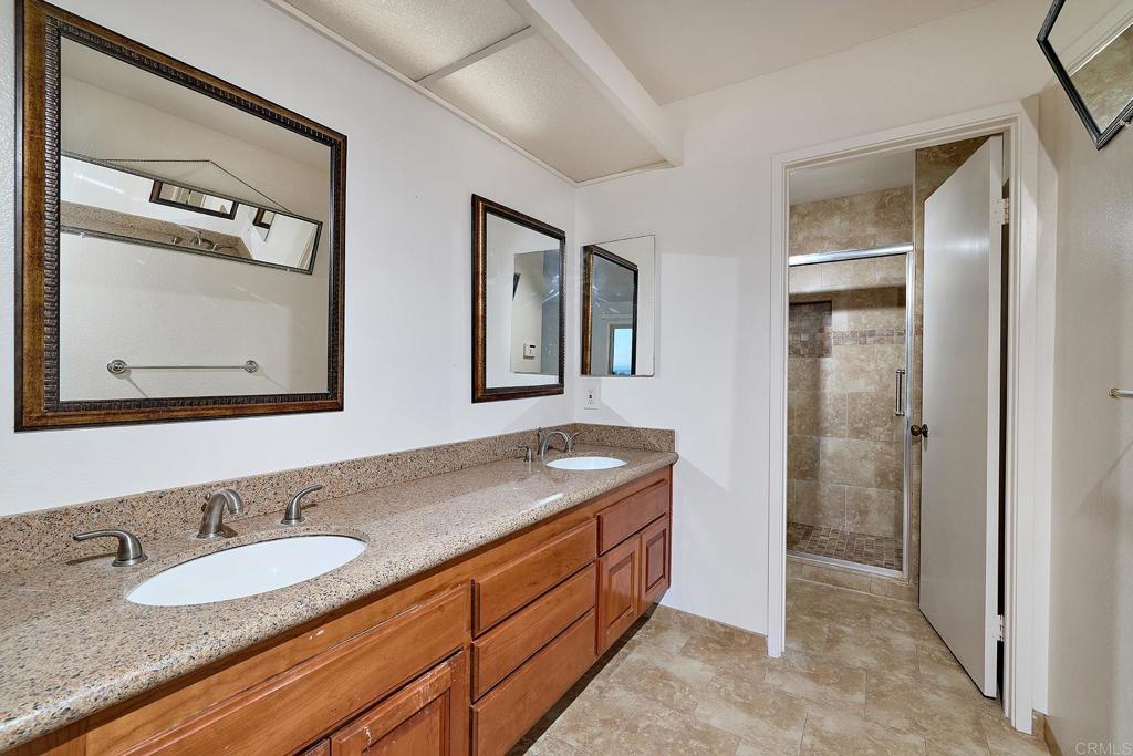 1068 Passiflora Avenue Encinitas, CA 92024 - Photo 21 of 38 a bathroom with a granite countertop double vanity sink and a mirror