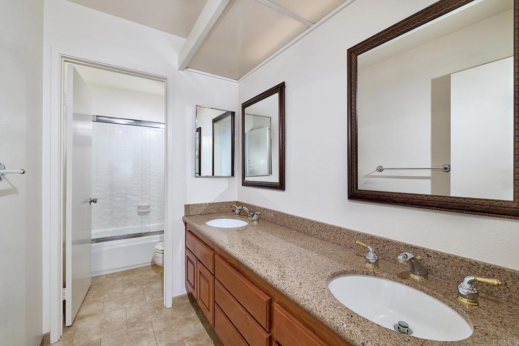 1068 Passiflora Avenue Encinitas, CA 92024 - Photo 26 of 38 a bathroom with a granite countertop double vanity sink mirror and bathtub