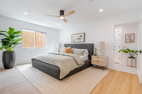 a spacious bedroom with a bed and a ceiling fan