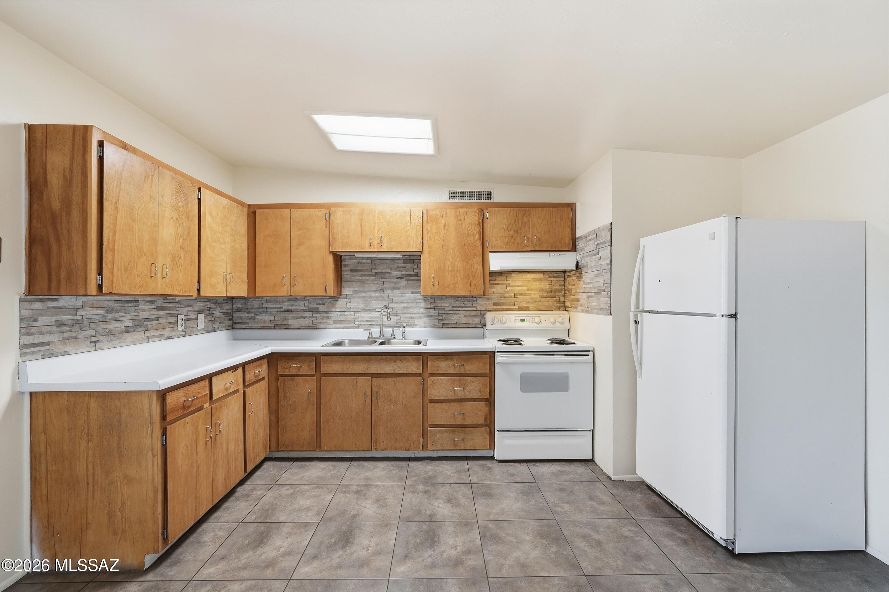 1808 West Caravelle Road Tucson, AZ 85713 - Photo 13 of 38 a kitchen with a sink stove and refrigerator