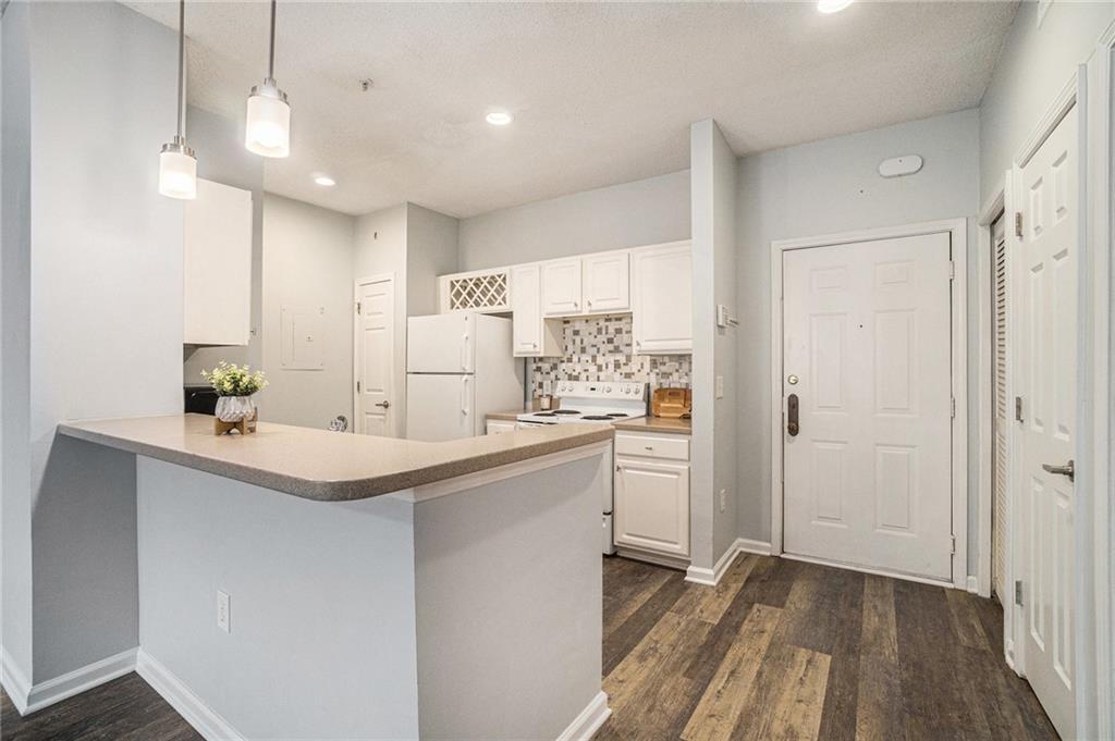 955 Juniper Street Northeast, Unit 3026 Atlanta, GA 30309 - Photo 11 of 32 a kitchen with sink refrigerator and cabinets
