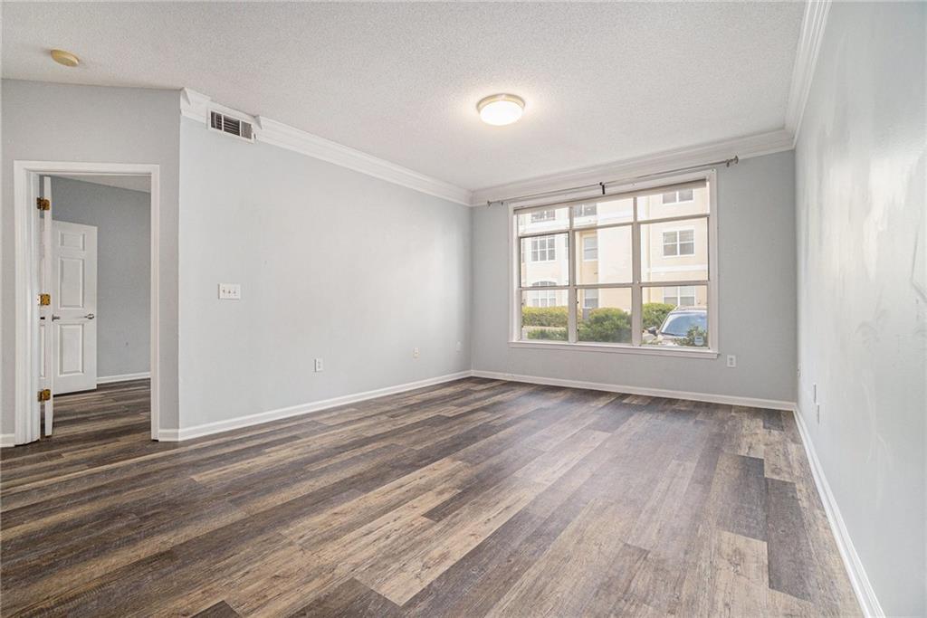 955 Juniper Street Northeast, Unit 3026 Atlanta, GA 30309 - Photo 13 of 32 a view of an empty room with wooden floor and a window