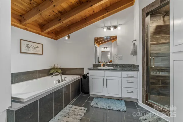 a bathroom with a tub sink and mirror