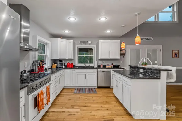 a kitchen with stainless steel appliances granite countertop a stove and cabinets