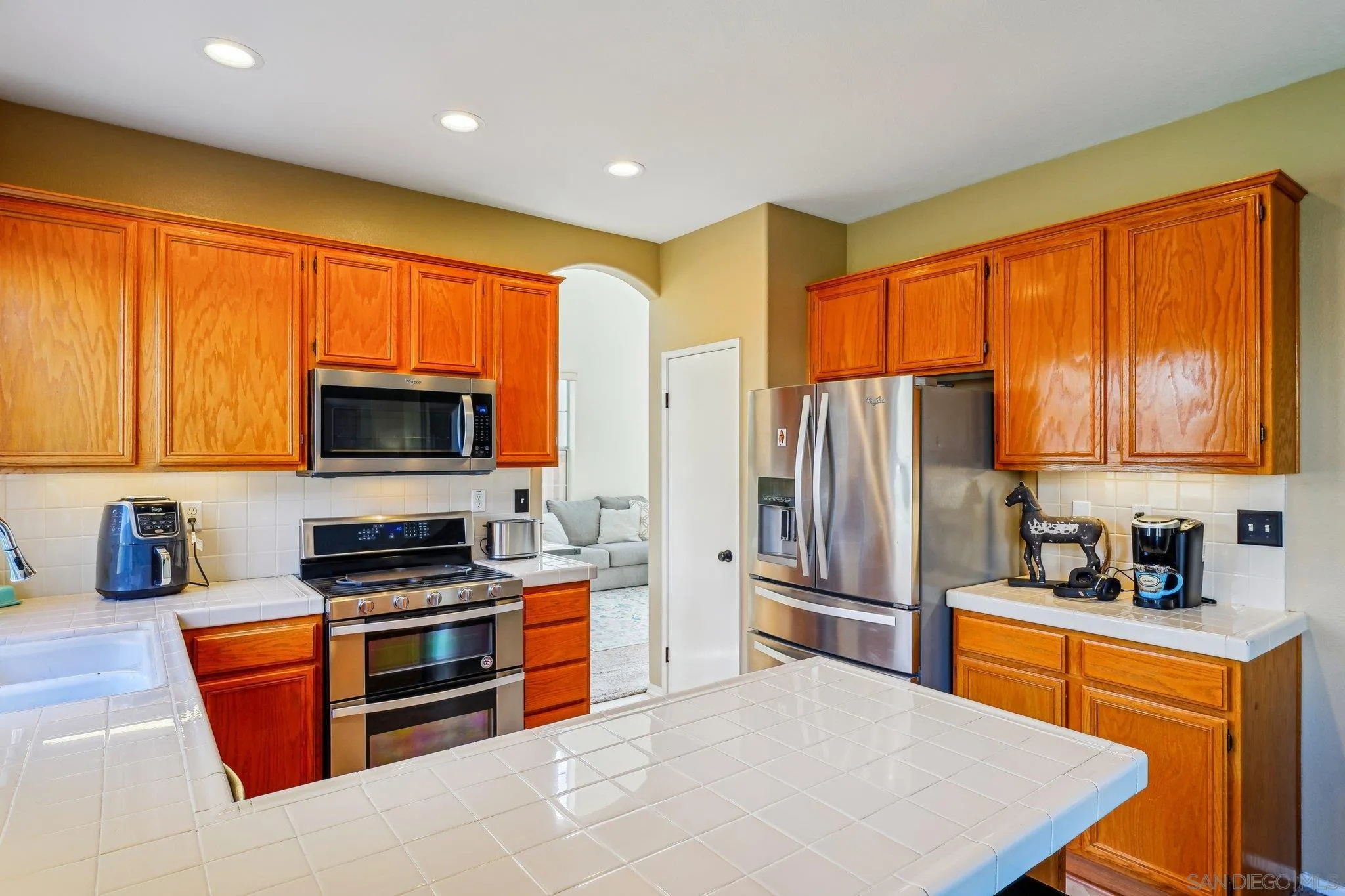 43166 Sereno Drive Temecula, CA 92592 - Photo 19 of 44 a kitchen with stainless steel appliances granite countertop a stove top oven a sink dishwasher a refrigerator and cabinets with wooden floor
