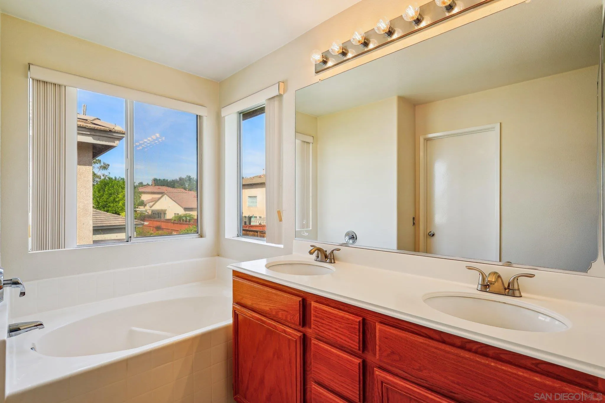 43166 Sereno Drive Temecula, CA 92592 - Photo 25 of 44 a bathroom with a tub sink and mirror