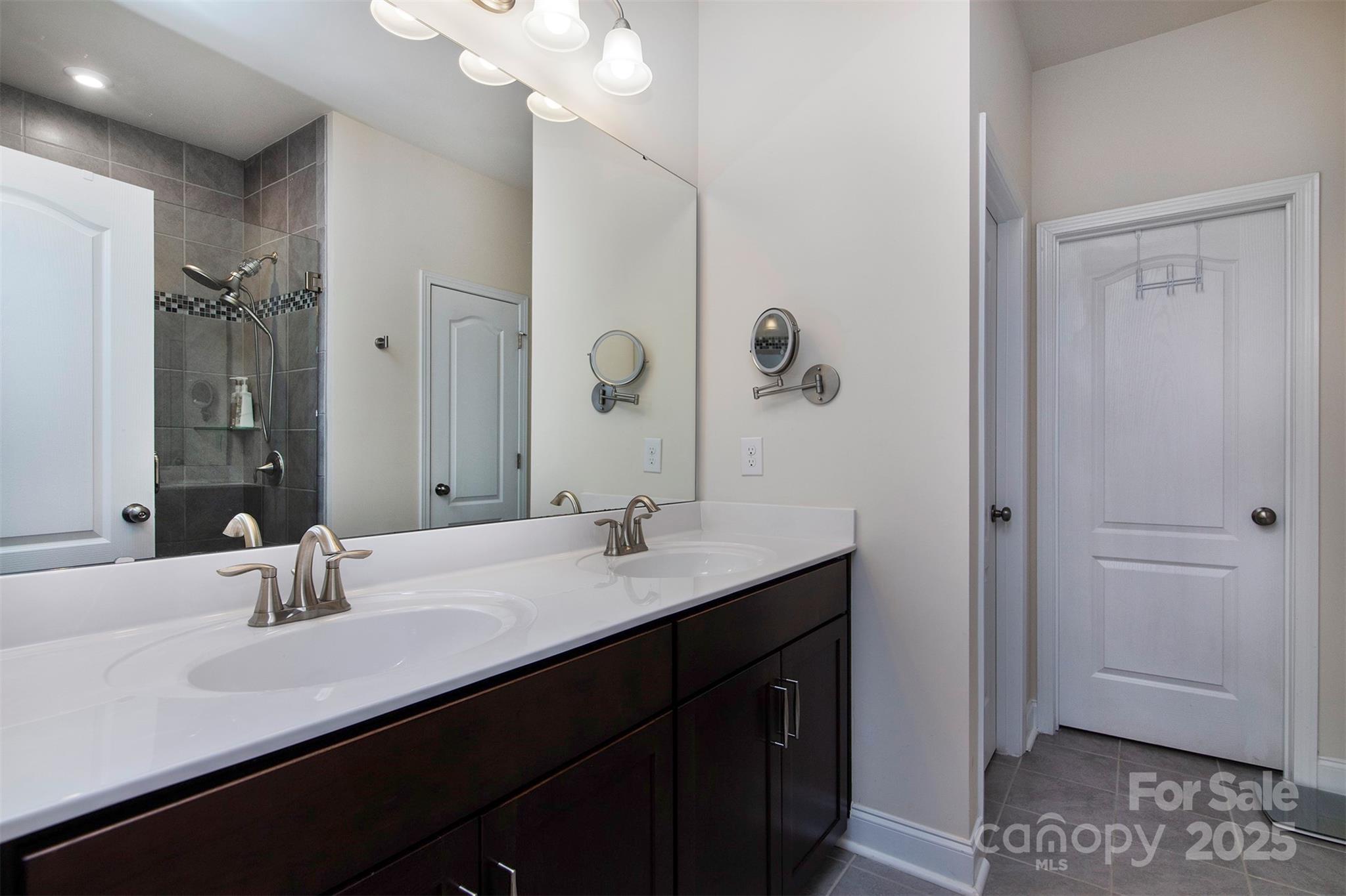 938 Moose Trail Matthews, NC 28104 - Photo 13 of 23 a bathroom with a double vanity sink a mirror and shower