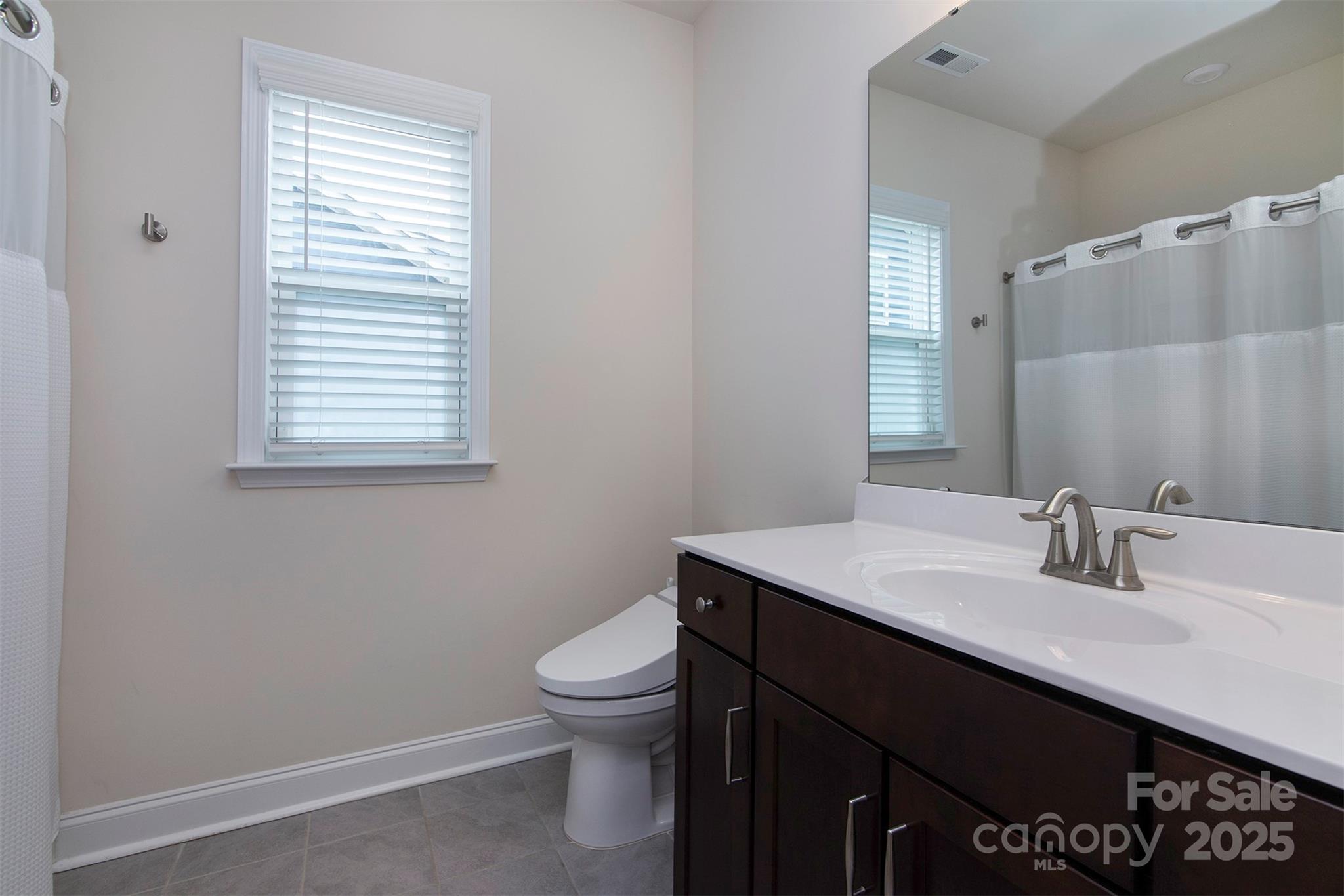 938 Moose Trail Matthews, NC 28104 - Photo 16 of 23 a bathroom with a sink a toilet and a mirror