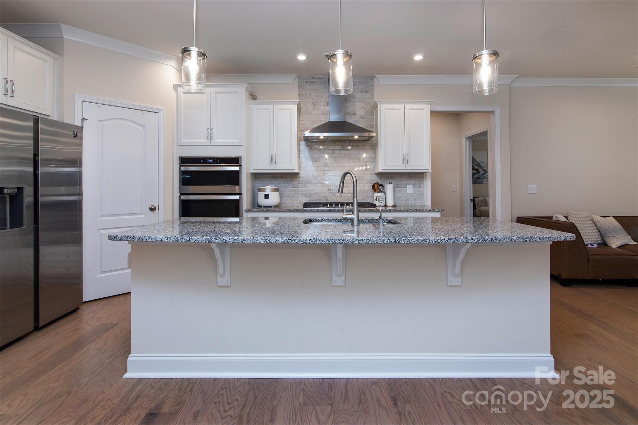 938 Moose Trail Matthews, NC 28104 - Photo 3 of 23 a kitchen with kitchen island granite countertop a refrigerator a stove a sink and a oven