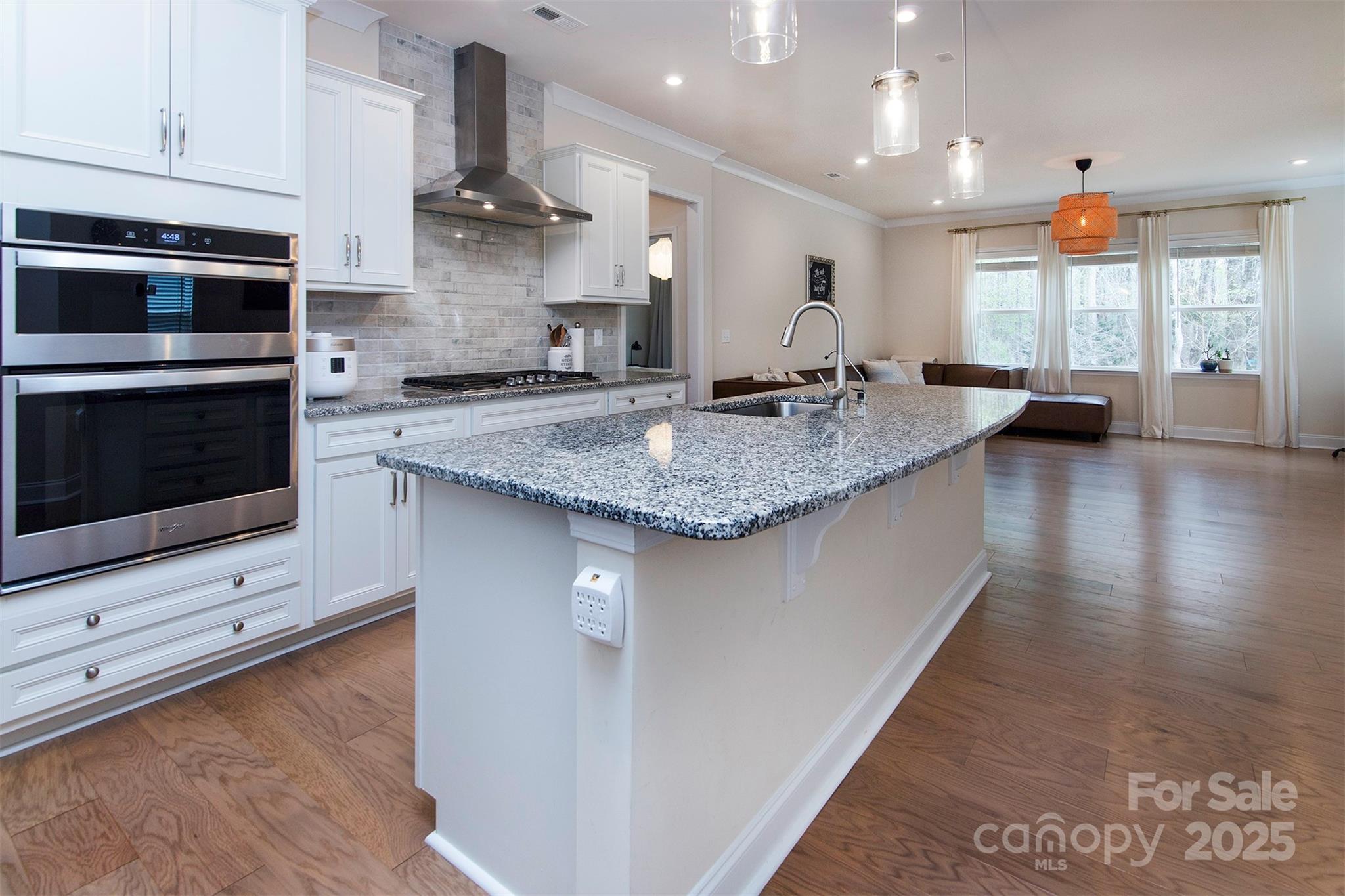 938 Moose Trail Matthews, NC 28104 - Photo 4 of 23 a kitchen with stainless steel appliances granite countertop a sink a stove and a microwave