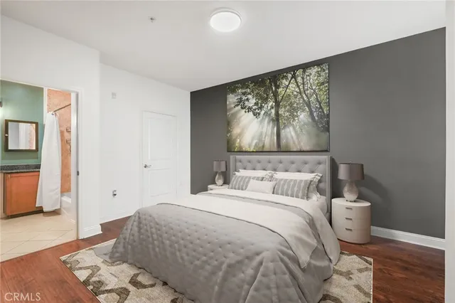 a bedroom with a large bed and wooden floor