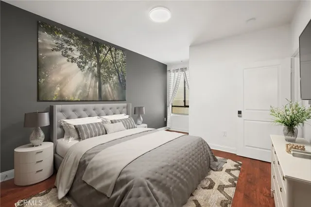 a bedroom with a large bed and a potted plant