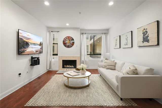a living room with furniture a flat screen tv and a fireplace