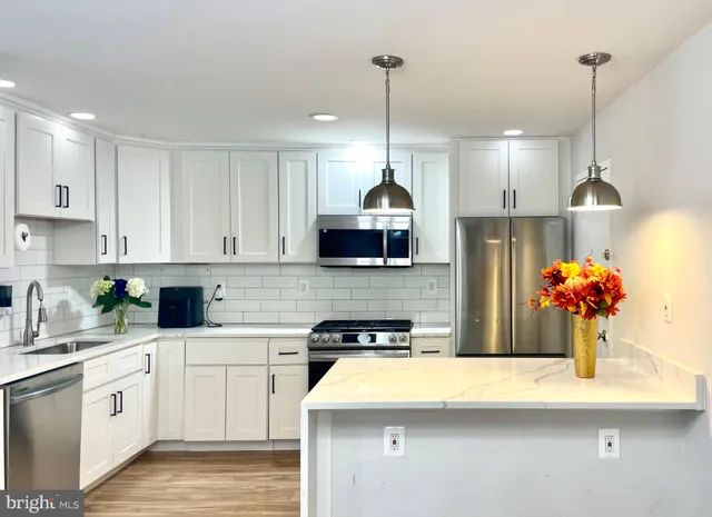 a kitchen with stainless steel appliances kitchen island granite countertop a sink a stove and cabinets