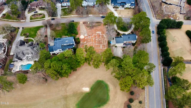 an aerial view of a house with a yard and lake view