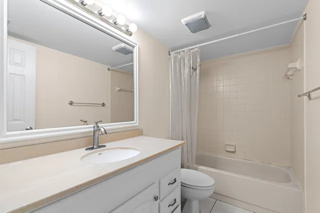 a bathroom with a granite countertop sink a toilet and shower