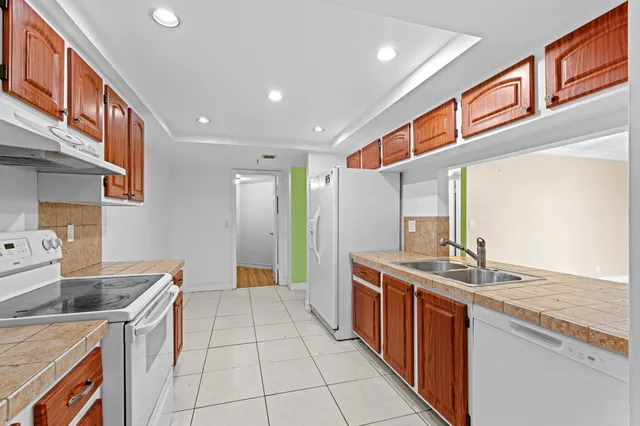 a kitchen with stainless steel appliances granite countertop a sink and a stove