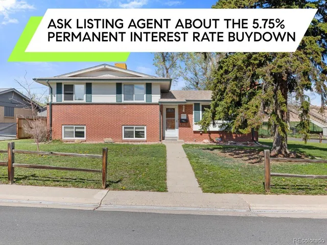a front view of a house with a garden and tree