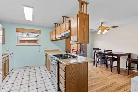 a kitchen with a stove a sink a dining table and chairs