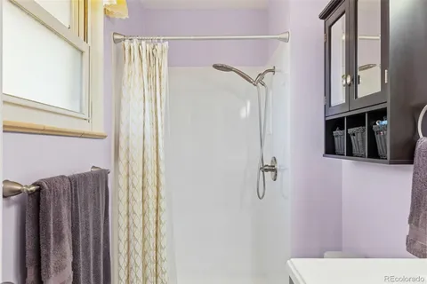 a bathroom with a shower curtain and a window
