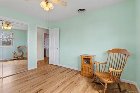 a view of a hallway with wooden floor and furniture