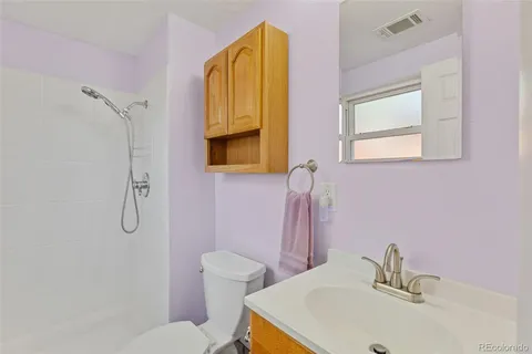 a bathroom with a sink mirror vanity and toilet