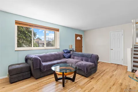 a living room with furniture and a window with wooden floor