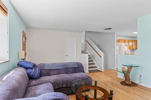 a living room with furniture and a wooden floor