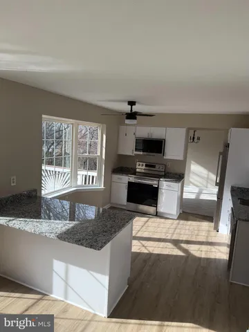 a kitchen with granite countertop a refrigerator and a sink