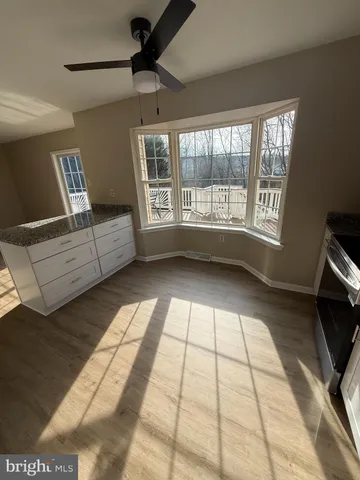 a view of empty room with a fireplace and fan