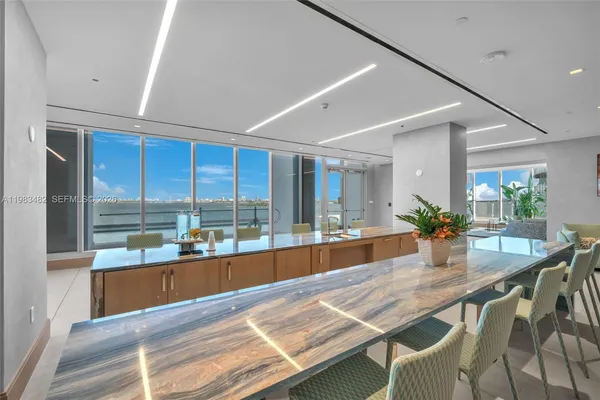 a dining room with furniture and a floor to ceiling window