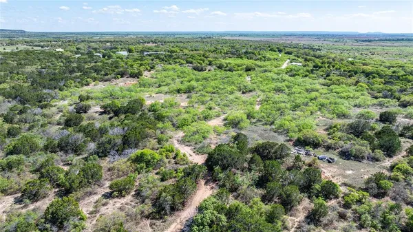 an aerial view of residential houses with outdoor space and trees